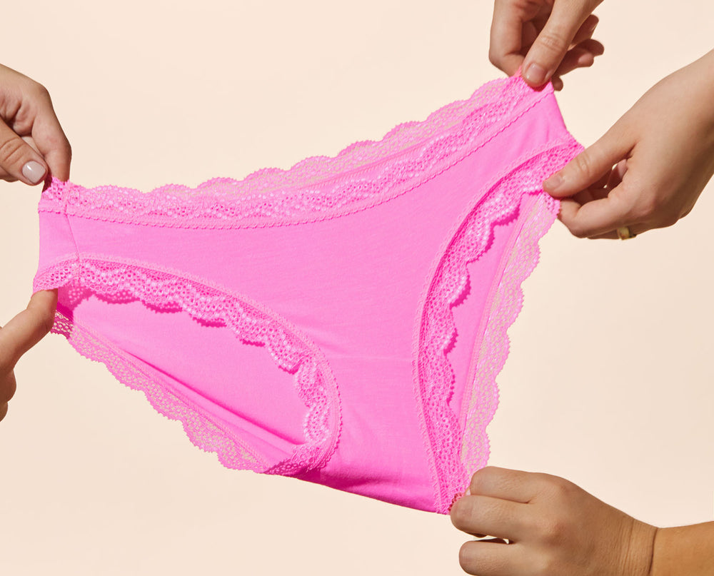 Hands holding a pair of hot pink knickers